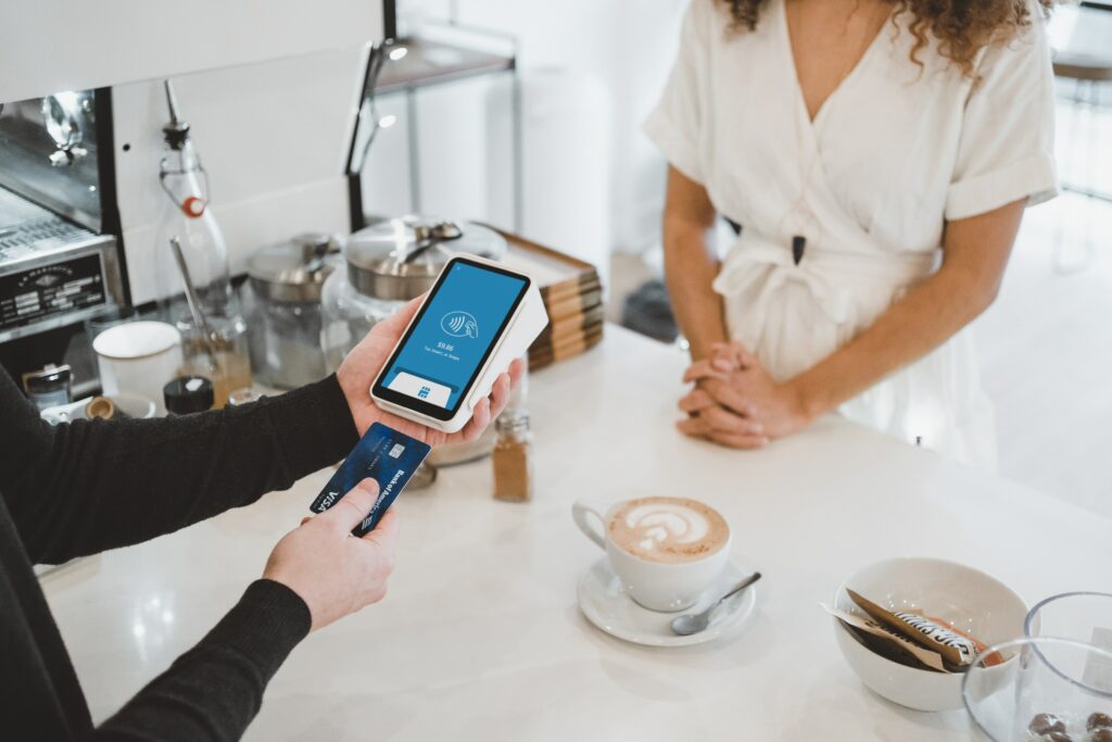 Woman putting card into machine to pay for coffee